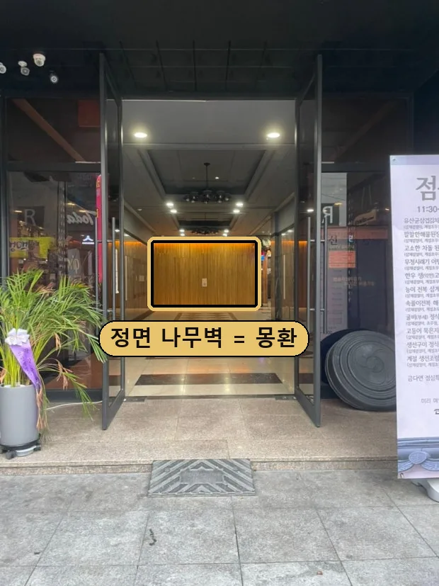 줄리아나 입구의 유리문 안쪽 로비, 정면에 나무벽